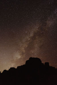 Low angle view of silhouette mountain against star field