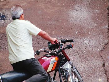 Rear view of man riding bicycle on city