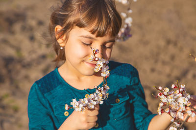 Smiling girl smelling flower