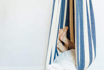 Low section of woman standing on bed at home