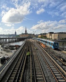 Railroad tracks in city against sky