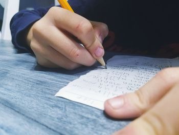 Close-up of hands writing on paper