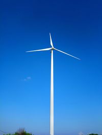 Low angle view of wind turbine against blue sky