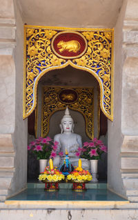 Buddha statue in front of temple outside building