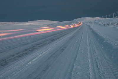 Aerial view of snow covered land against sky