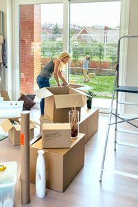 Mother unpacking while son playing soccer in lawn