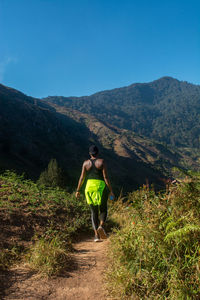 Rear view of woman standing on mountain