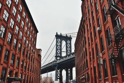 Low angle view of suspension bridge in city