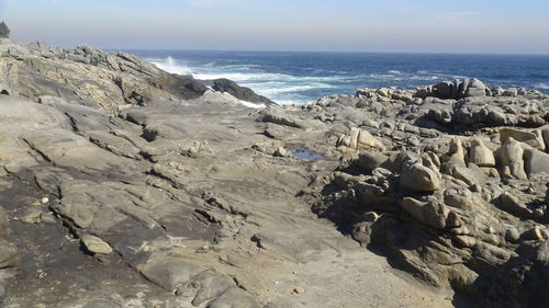 Scenic view of rocks on beach against sky