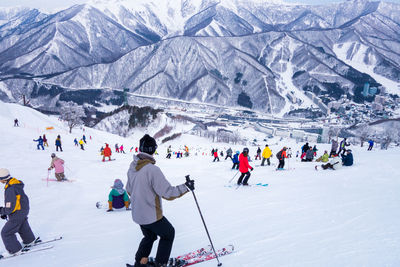 People skiing on snowcapped mountain during winter