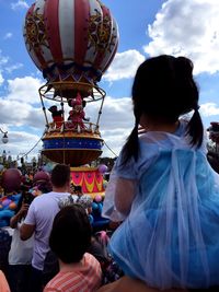 Rear view of people walking against sky