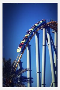 Low angle view of ferris wheel against blue sky