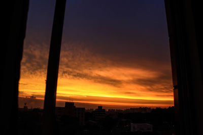 Silhouette of buildings against cloudy sky