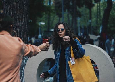 Young woman with sunglasses standing on street in city
