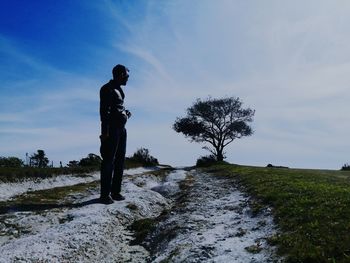 Silhouette man standing on field against sky