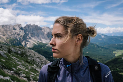 Close-up of young woman looking away against sky