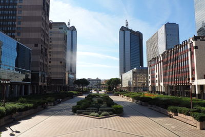 Footpath against skyscrapers in city