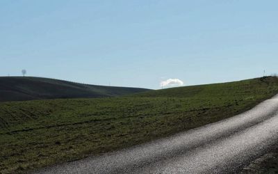 Scenic view of grassy field against cloudy sky