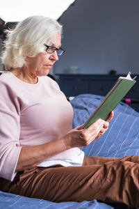 Young woman using mobile phone while sitting on sofa at home