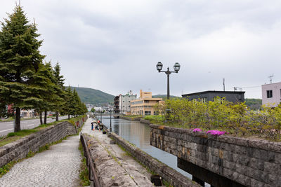 Reflecting canals in otaru under cloudy skies.