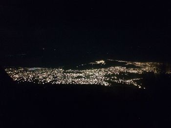 Illuminated city against sky at night