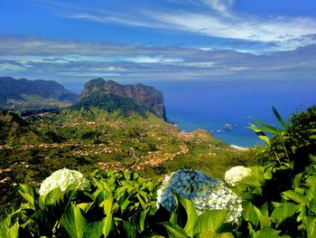 Scenic view of sea and mountains against sky