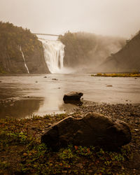 Scenic view of waterfall against sky