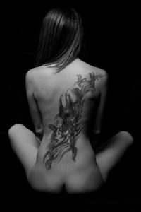 Rear view of a young woman against black background