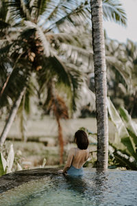 Rear view of woman swimming in water