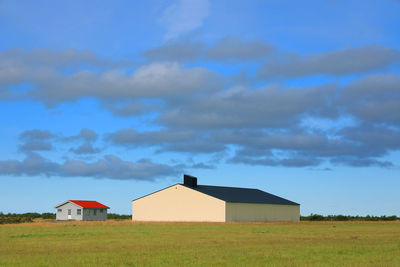 Houses on field against sky