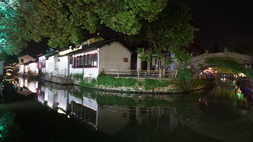 View of canal along buildings at night