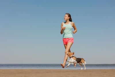 Side view of woman with dog at beach