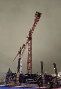 Low angle view of crane against sky