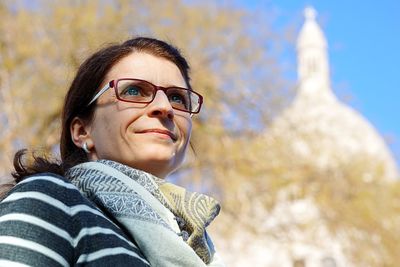 Low angle view of woman looking away against trees