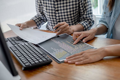 Midsection of woman using laptop on table