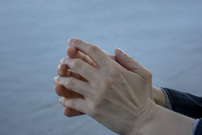 Close-up of hand holding hands against blurred background