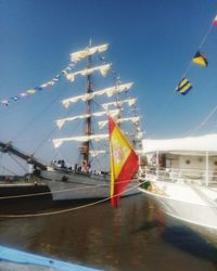 Sailboats moored on pole against sky