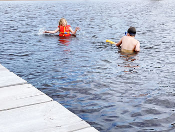 Rear view of two men sitting in water