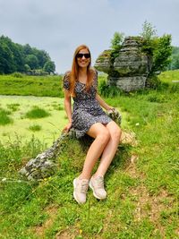 Portrait of young woman sitting on field