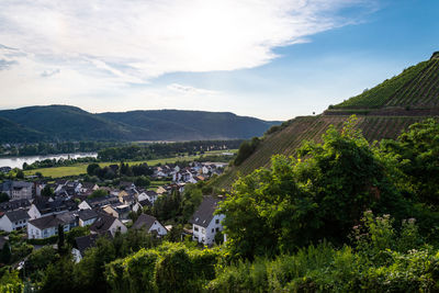 Scenic view of townscape by mountains against sky