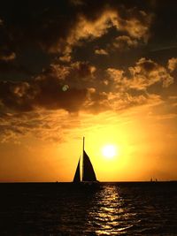 Silhouette of boat in sea at sunset