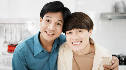 Gay couple cooking sandwich breakfast together in kitchen. happy lgbtq family activity together