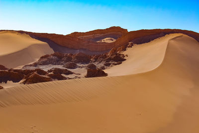 Sand dunes in desert against sky