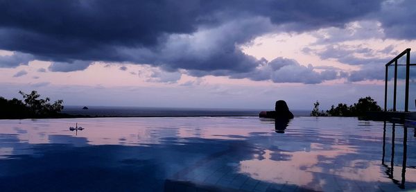 View of swimming pool by sea against sky