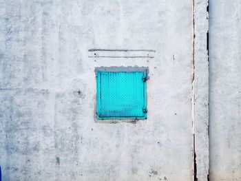 Close-up of blue window on white wall