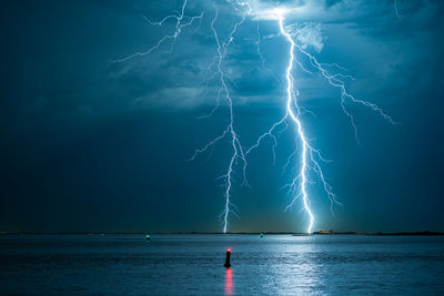 Powerful forked lightning bolts over water