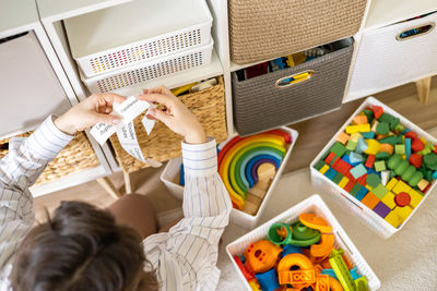 High angle view of boy playing with toy on bed at home