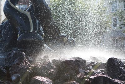 Blurred motion of man splashing water on rocks