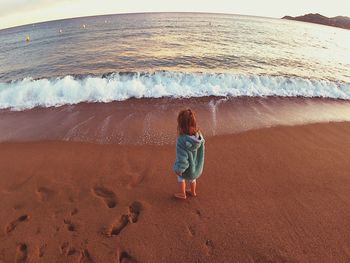 Rear view of boy standing on beach