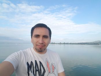 Portrait of young man against sea